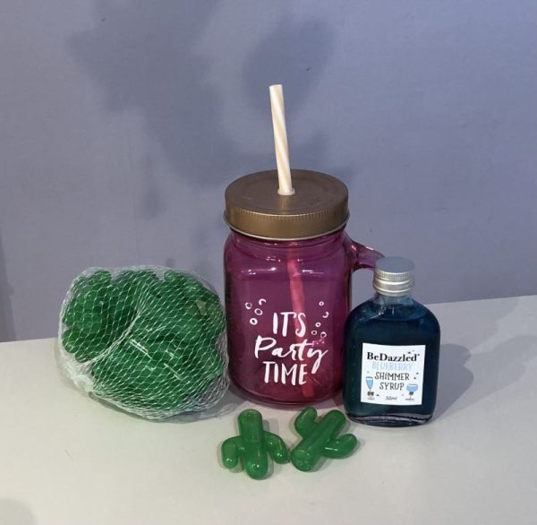 Drink shimmer party gift basket. Wicker storage basket with a pink mason jar saying It's party time, reusable ice cubes and a bottle of flavoured drink shimmer