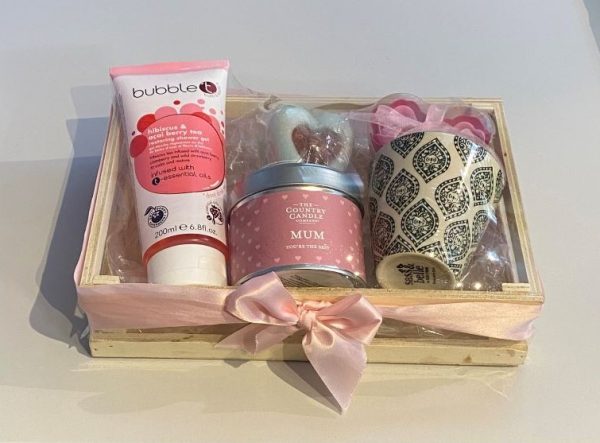 Mother's Day pampering gift. Wooden storage crate filled with scented candle, shower gel, soap roses, soap cake and mini plant pot